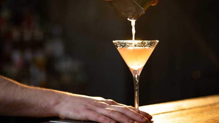 VERRE D'UN COCKTAILS DANS UN VERRE À MARTINI DE COULEUR DORÉ