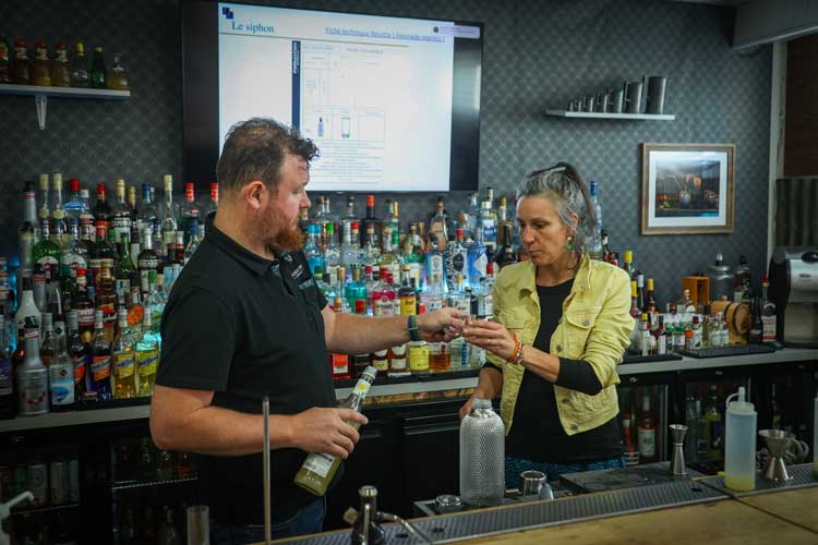 une barmaid et un barman en entrainement de création de cocktails dans un bar
